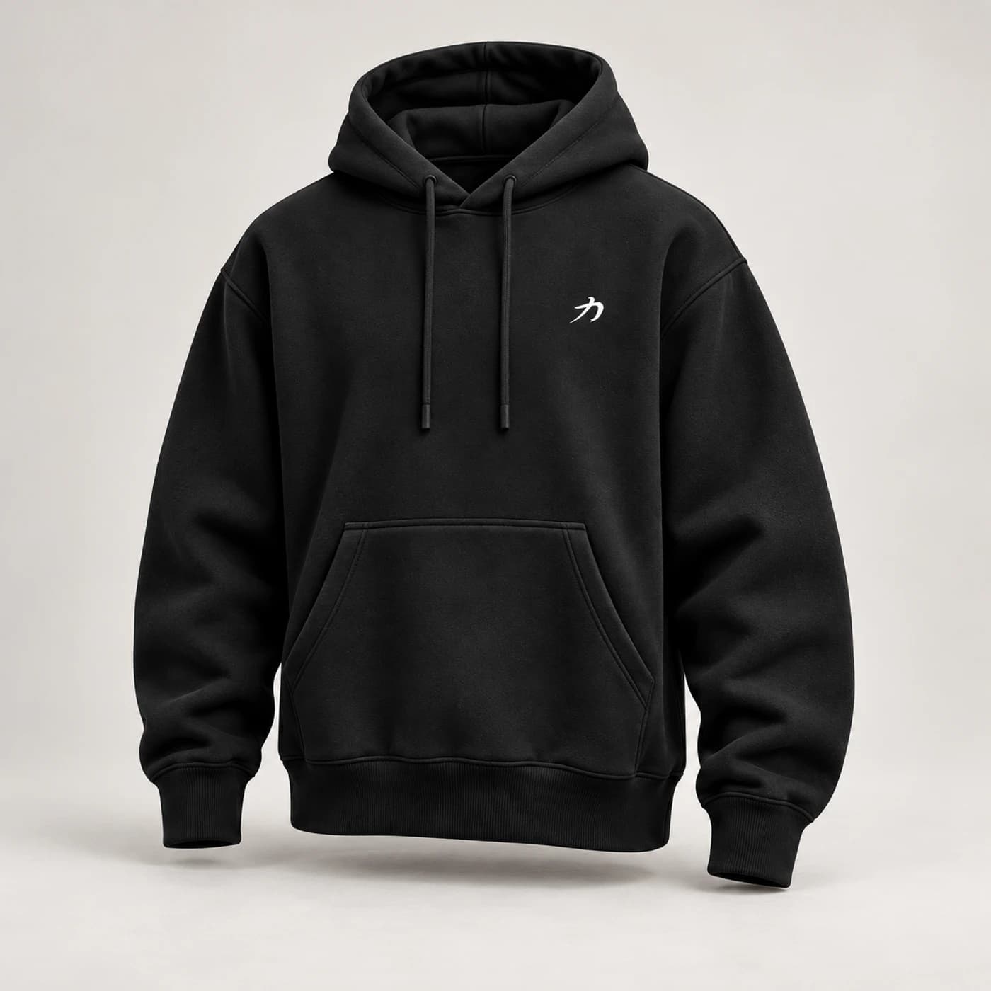 Black oversized SAEE hoodie with a small white chest-side strength emblem, photographed without a model